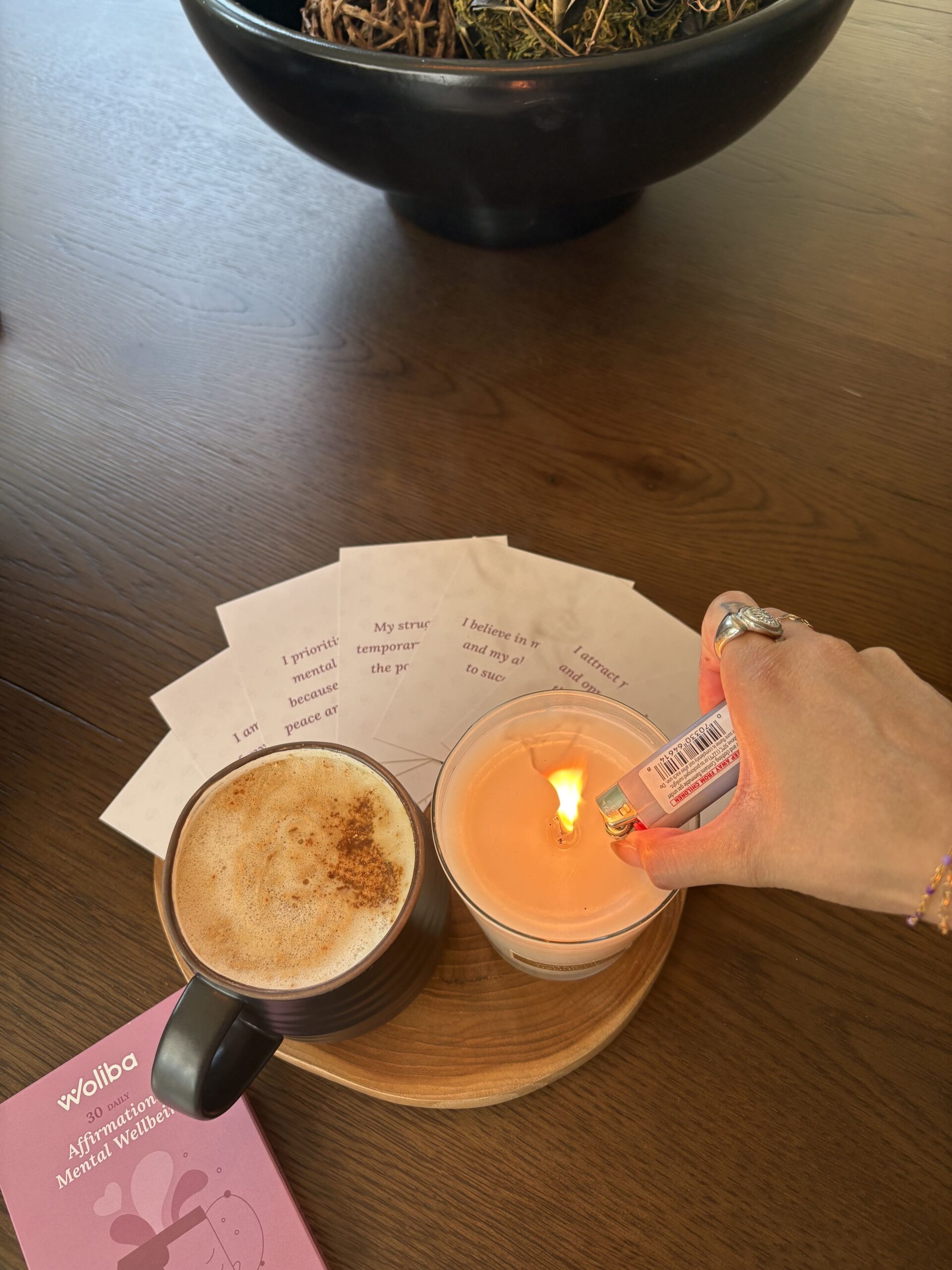 A stack of affirmation cards on a desk surrounded by plants and notebooks, symbolizing mindfulness, positivity, and workplace wellbeing.