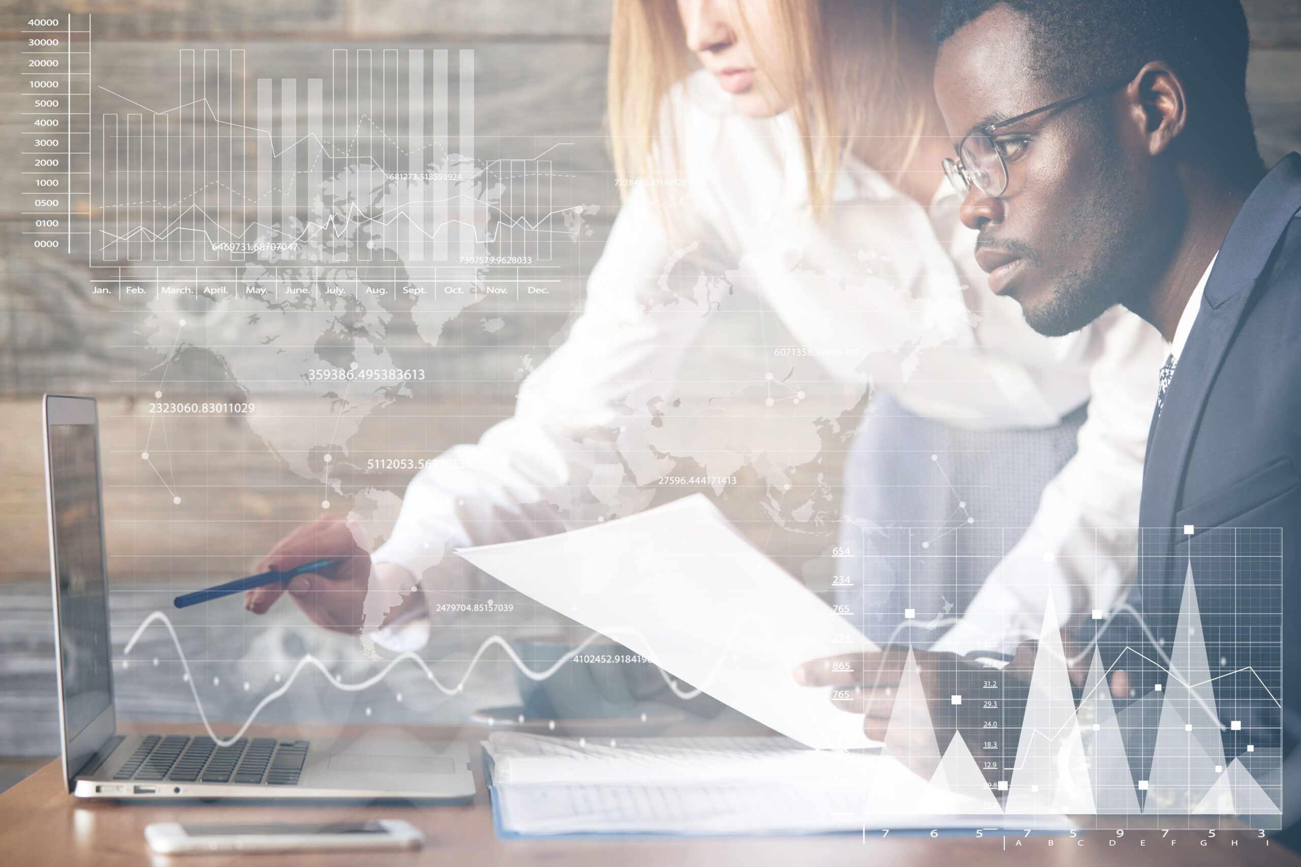 Two business professionals reviewing reports and digital analytics dashboards on a laptop, representing employer evaluation of wellness program performance, data integration, and the shift from fragmented multi-vendor solutions to unified wellbeing platforms.