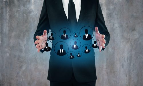 A business professional in a suit standing with hands open around a glowing hologram of team member icons, symbolizing a scalable people operations system and organized workforce management.