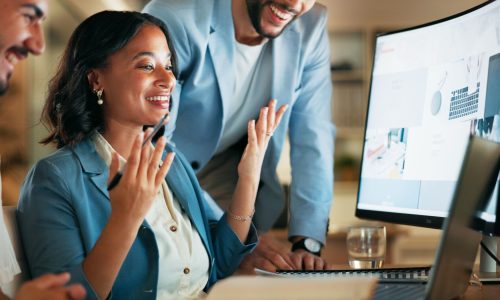 A team of professionals collaborates around a computer, reviewing real-time data on a large monitor—illustrating how TPAs use real-time health data to improve employer outcomes.